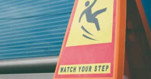 Warning signs warns visitors to watch their step to prevent slip and fall injuries