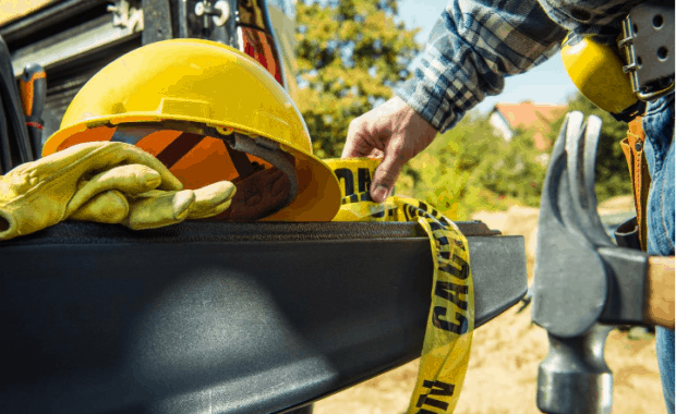Construction worker grabs safety gear out of truck bed to prevent construction injuries at worksite