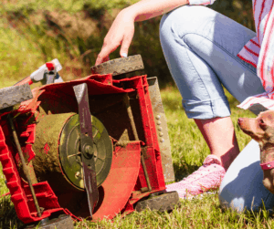 woman examines lawnmower for product defect