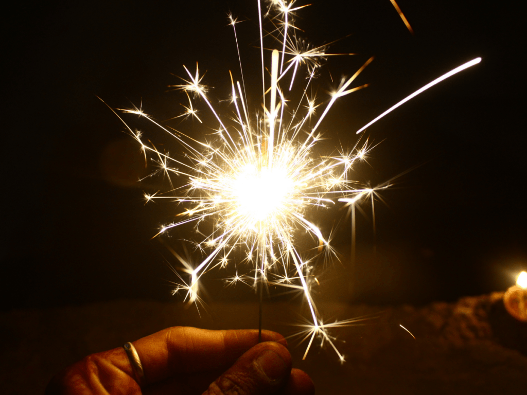 person practices fireworks safety while handling sparkler