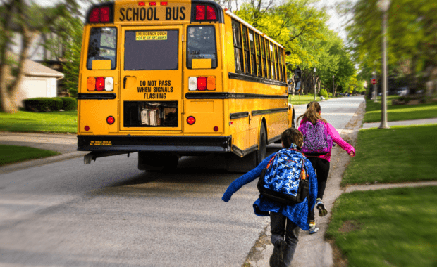 Students run to catch school bus to go back to school.