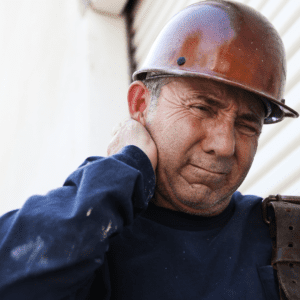 A construction worker struggles with the pain of a neck injury