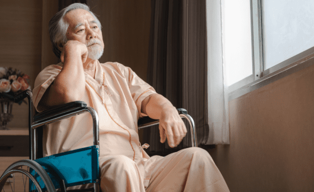 Man in nursing home feels withdrawn due to emotional elder abuse from the staff