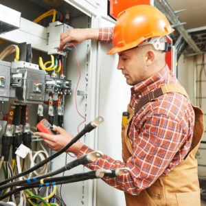 Electrician works on wiring and is cautious of sustaining a workplace burn injury due to faulty wiring.