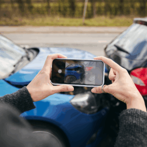 Driver photographing damage after a leased car accident for insurance report