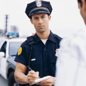 A police officer writing a report at a car accident site, highlighting the role of official documentation.